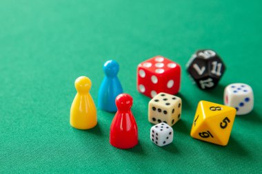 Renkli oyun yongaları masa oyunları için rakamlar. Yeşil tablo üzerinde zar küpleri topluluğu