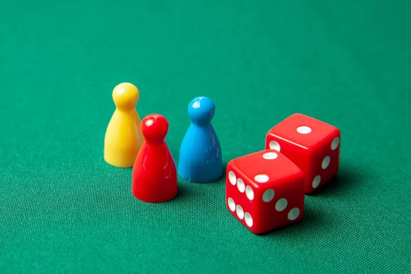 Renkli oyun yongaları masa oyunları için rakamlar. Yeşil tablo üzerinde zar küpleri topluluğu