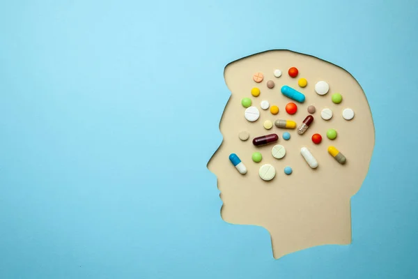 El perfil del hombre y en su cabeza un montón de pastillas. Tratamiento de la cefalea — Foto de Stock