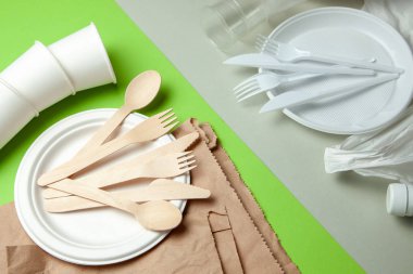 Çevre dostu tek kullanımlık sofra bambu ahşap ve kağıt yeşil bir arka plan üzerinde yapılmış. Plastik zararlı yemekler ve çatal bıçak takımı.