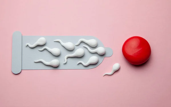 Torn damaged condom and active condoms float to the egg. Unexpected pregnancy, egg fertilization — Stock Photo, Image