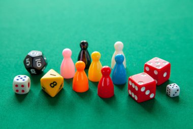 Renkli oyun yongaları masa oyunları için rakamlar. Yeşil tablo üzerinde zar küpleri topluluğu