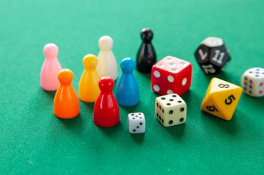 Renkli oyun yongaları masa oyunları için rakamlar. Yeşil tablo üzerinde zar küpleri topluluğu