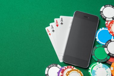 Cep telefonu casino online. Cep telefonu ve oyun kartları yeşil oyun masa yongaları ile. Kumar bağımlılığı Oyunlar çatlama içinde