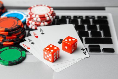 Online casino laptop. Laptop klavye ve zar ve iskambil yeşil bir oyun tablo ile fiş. Oyun bağımlılığı kumar