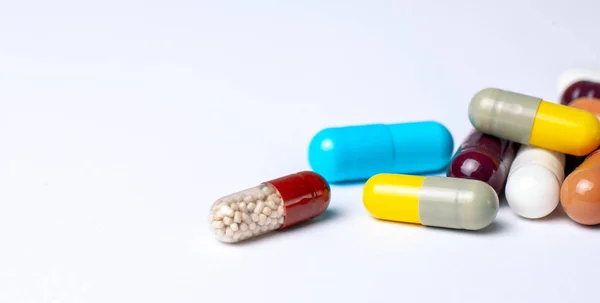 Pillole colorate in capsule su sfondo grigio — Foto Stock
