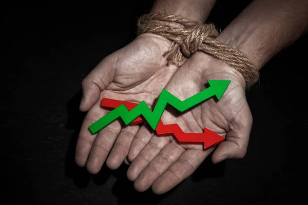 Man with hands tied with rope, in the palms of the growth arrow up green and red. Growth restraint — Stock Photo, Image