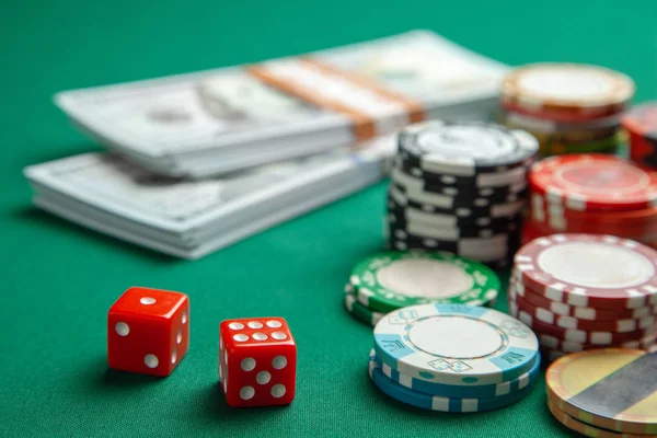 Casino, kumar kavramının poker spor. Kırmızı oyun zar ve yeşil oyun masa üzerinde nakit para dolarla renkli patates kızartması. — Stok fotoğraf