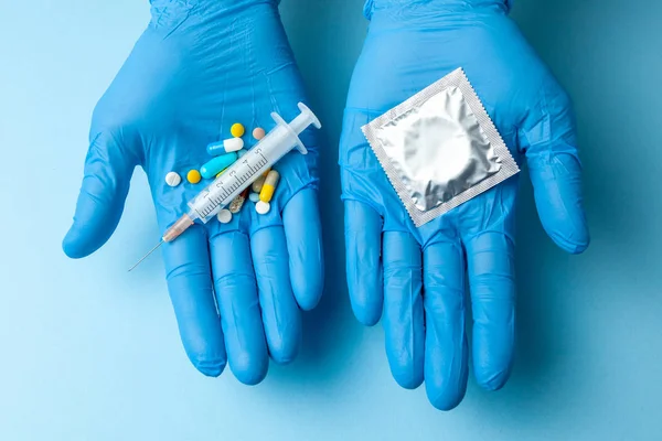 Concepto de elección de anticoncepción, píldora o condón. médico en la mano son píldoras anticonceptivas y jeringa, y en condón de segunda mano — Foto de Stock