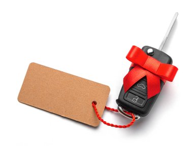 Arabanın anahtarlarını uzaktan kumanda alarm etiket ve yayla kırmızı kurdele ile birlikte hediye. Beyaz arka plan üzerinde izole.