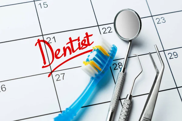 Dentist note on the calendar. Toothbrush and dental tools mirror, prince, hook on the calendar.