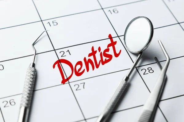 Dentist note on the calendar. Dental tools mirror, prince, hook on the calendar.