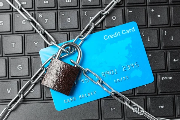 Credit card in chain with lock on laptop keyboard. Ban online payments and purchases in the online store