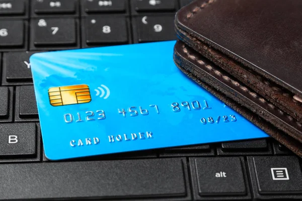 Credit card with a wallet on the keyboard of laptop. Buying in the online store