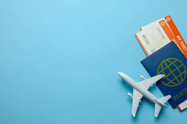 Billetes para avión y pasaporte con modelo de avión de pasajeros sobre fondo azul. Copiar espacio para texto . —  Fotos de Stock