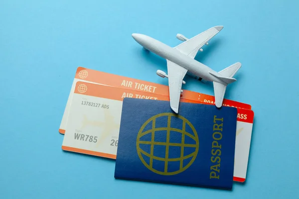 Tickets for plane and passport with model of passenger plane on blue background — Stock Photo, Image