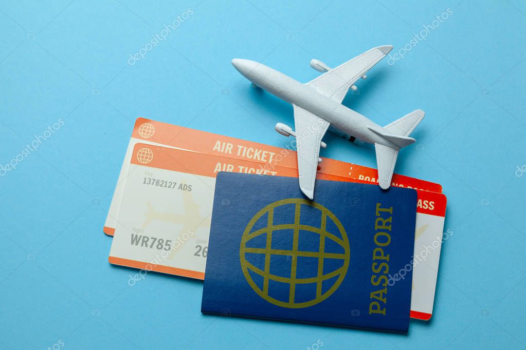 Billetes para avión y pasaporte con modelo de avión de pasajeros sobre