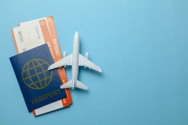 Mavi arka plan üzerinde yolcu uçağı modeli ile pasaport ve uçak biletleri. Metin için yer kopyalayın