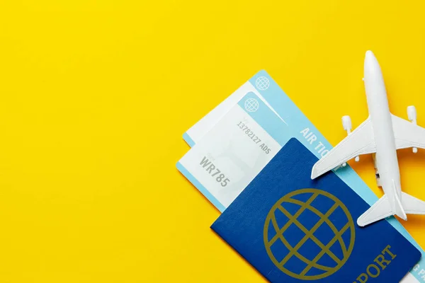 Billetes para avión y pasaporte con modelo de avión de pasajeros sobre fondo amarillo. Copiar espacio para texto — Foto de Stock