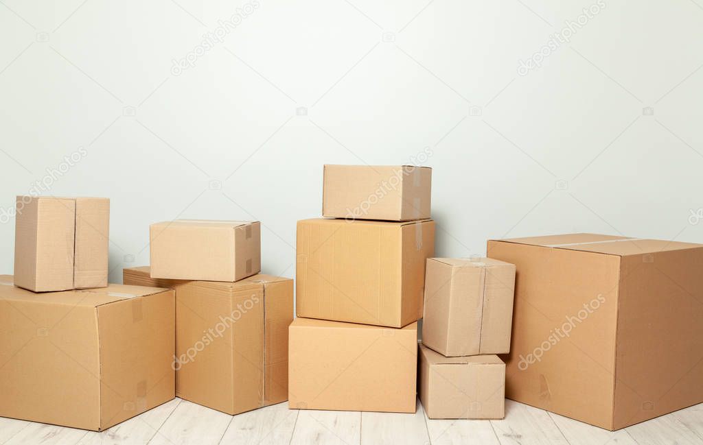 Day moving. Delivery of goods, shopping. Cardboard boxes on gray wall background