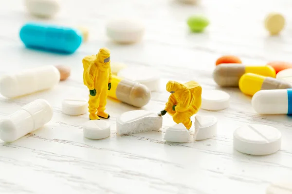 Los científicos están probando nuevas píldoras. Investigación de drogas. Médico en traje bioprotector examina medicamentos . — Foto de Stock