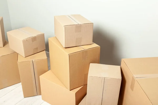 Dia a andar. Entrega de mercadorias, compras. Caixas de papelão no fundo da parede cinza — Fotografia de Stock