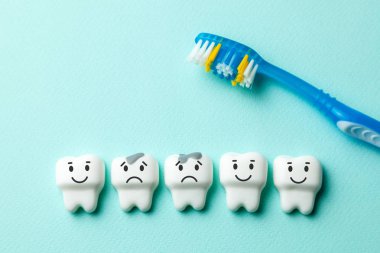 Sağlıklı beyaz dişler gülümsüyor ve diş çürüğü ile yeşil nane arka plan ve diş fırçası üzücü.