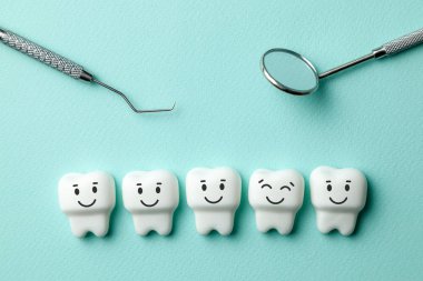 Sağlıklı dişler beyaz yeşil nane arka plan ve diş hekimi araçları ayna gülümseyerek, kanca.