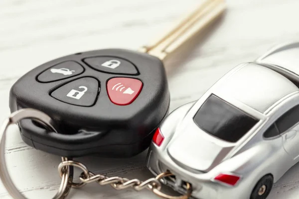 Bilnycklar med fjärrkontroll säkerhet och bil Nyckelknippa på vit trä bakgrund — Stockfoto