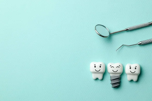 Sağlıklı beyaz dişler ve implantlar yeşil nane arka plan ve diş hekimi araçları ayna gülümseyerek, kanca. Metin için yer kopyalayın.