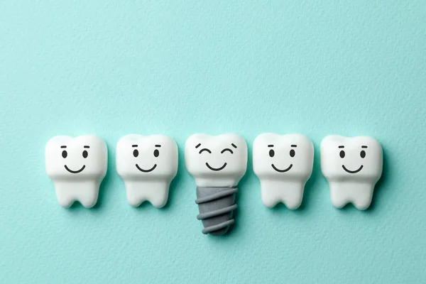 Healthy white teeth and implants are smiling on green mint background. Copy space for text.