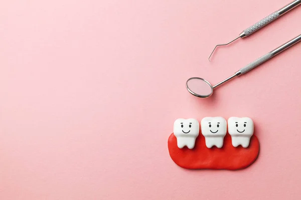 Dentes brancos saudáveis estão sorrindo no fundo rosa e ferramentas de dentista espelho, gancho. Espaço de cópia para texto . — Fotografia de Stock