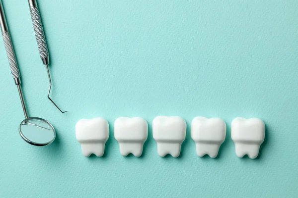 Egészséges fehér fogak, a zöld menta háttér és a fogorvos eszközöket tükör, kampó. — Stock Fotó