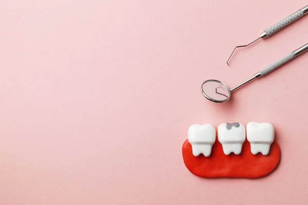 Здорові білі зуби та зуби з карієсом на рожевому фоні та інструменти стоматолога дзеркало, гачок. Копіювати простір для тексту . — стокове фото