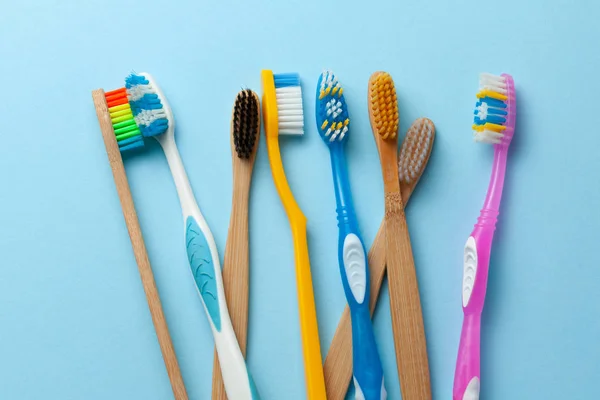 Escovas de dentes coloridas em fundo azul . — Fotografia de Stock