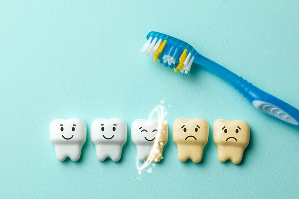Clareamento dos dentes. Dentes brancos saudáveis estão sorrindo e amarelo de cigarros e café triste em fundo de hortelã verde com escova de dentes — Fotografia de Stock