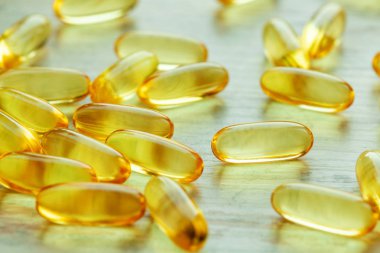 Sarı balık yağı ve omega-3 kapsül masada.