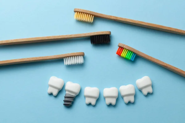 Dentes brancos saudáveis e implantes em fundo azul com escova de dentes — Fotografia de Stock