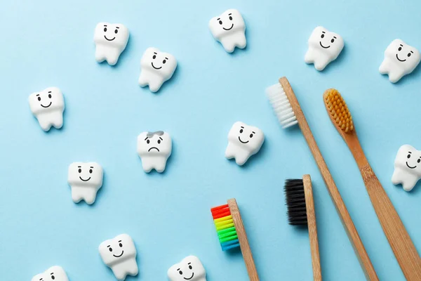 Dentes brancos saudáveis estão sorrindo e dente com cárie é triste no fundo azul e escova de dentes . — Fotografia de Stock