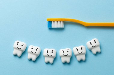 Sağlıklı dişler beyaz diş fırçası ile mavi arka plan üzerinde gülümseyen