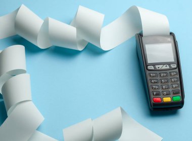 Terminal nakit kayıt makinesi POS ödeme ve mavi arka planda uzun rulo nakit bant. Metin için boşluk Kopyala.