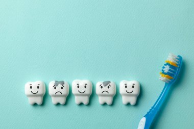 Sağlıklı beyaz dişler gülümsüyor ve diş çürüğü ile yeşil nane arka plan ve diş fırçası üzücü.