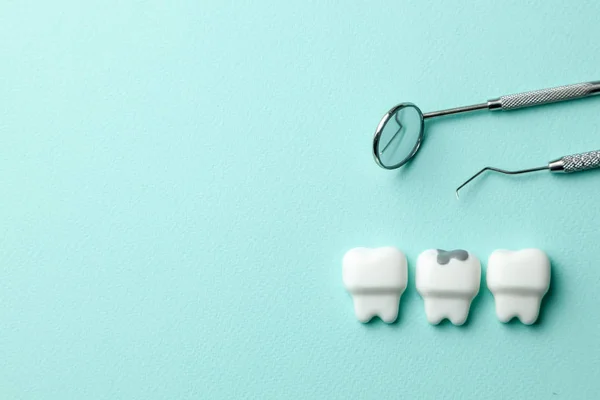 Υγιή λευκά δόντια και δόντι με τερηδόνα σε πράσινο Νομισματοκοπείο και εργαλεία οδοντίατρου καθρέφτη, γάντζος. Αντιγραφή χώρου για κείμενο. — Φωτογραφία Αρχείου