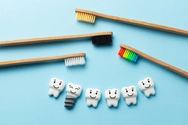 Dentes brancos saudáveis e implantes estão sorrindo no fundo azul com escova de dentes — Fotografia de Stock