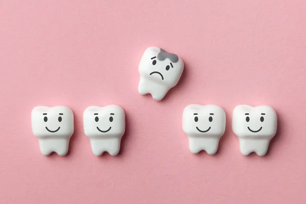 Dientes blancos sanos sonríen y quitar los dientes con caries es triste contra el gancho rosado . — Foto de Stock