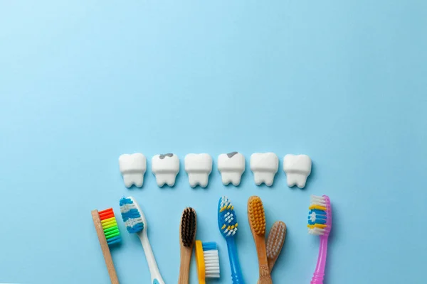 Healthy white teeth and tooth with caries is sad on blue background and Toothbrush. Copy space for text. — Stock Photo, Image