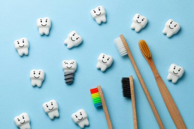 Sağlıklı beyaz dişler ve implantlar diş fırçası ile mavi arka plan üzerinde gülümseyen