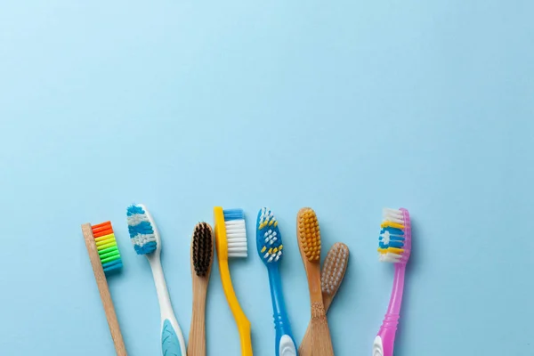 Escovas de dentes coloridas em fundo azul. Espaço de cópia para texto . — Fotografia de Stock
