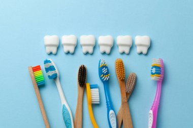 Diş fırçası ile mavi arka planda sağlıklı beyaz dişler