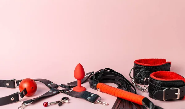 Set of erotic toys for BDSM. The game of sexual slavery with a whip, gag and butt plug. Intimate sex games. Copy space for text. — Stockfoto